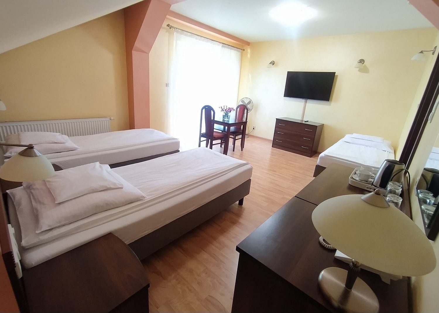 Pokój rodzinny w pensjonacie Kargul, trzy łóżka, telewizor, stolik przy oknie z wyjściem na balkon